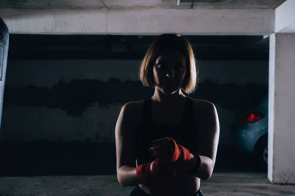 在车库里做红色拳击绷带的年轻女性轮廓 — 图库照片