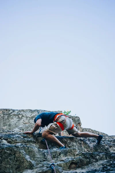 勇敢で自信に満ちたロッククライマーは彼女の登山ルート上でハード移動します — ストック写真