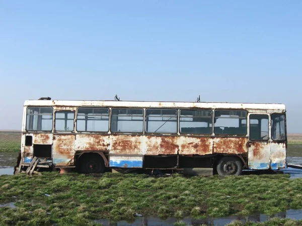 Old abandoned bus placed on the field and the weather deteriorates