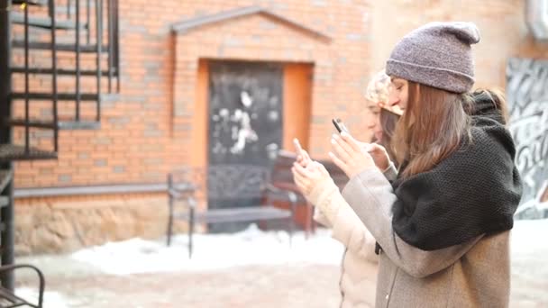 Zwei Mädchen stehen im Hof und fotografieren am Telefon — Stockvideo