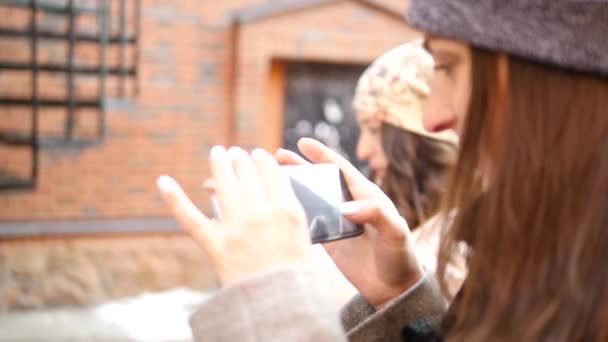 Två tjejer stå på gården och ta bilder på telefonen — Stockvideo