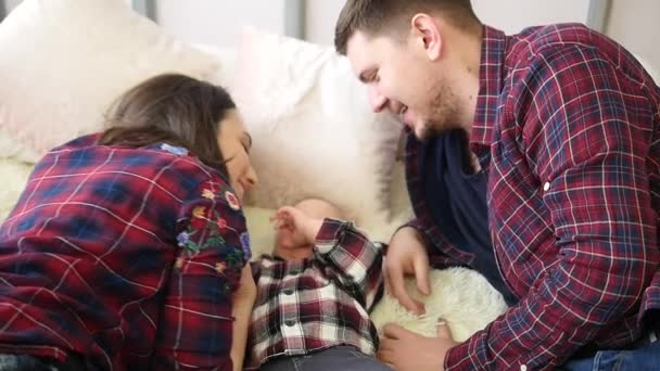 Genç güzel aile yatakta yatıyor ve çocuk öpücük — Stok video