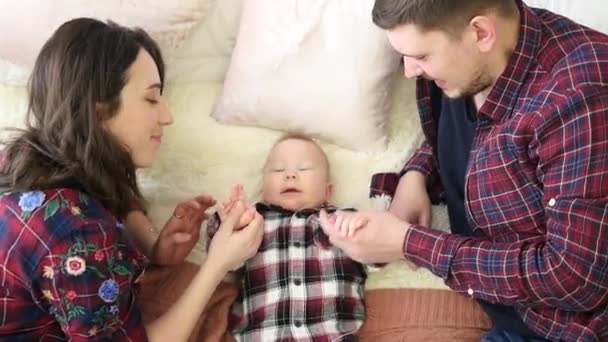 Familie: moeder, vader en baby dochter liggend op het bed. — Stockvideo