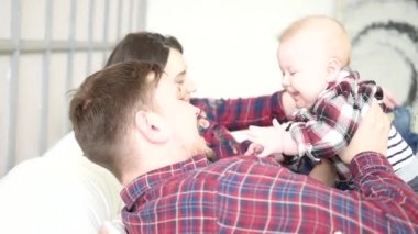 mutlu ebeveyn yatak odasında bedat üzerinde şirin bebek oğulları ile yalan