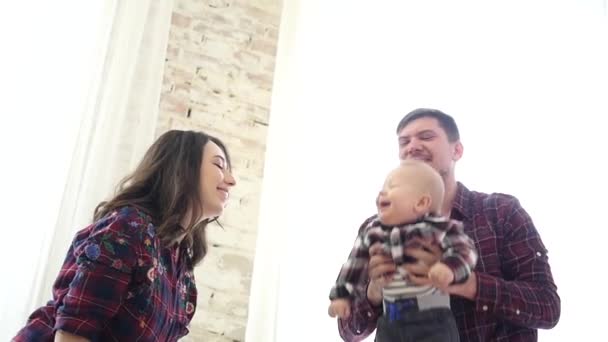 Šťastný mladý otec a matka, zvedání roztomilé dítě vysoko ve vzduchu. — Stock video