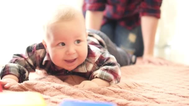 Lindo niño sonriente con hoyuelos en las mejillas y en pijama estrella arrastrándose en el suelo — Vídeo de stock