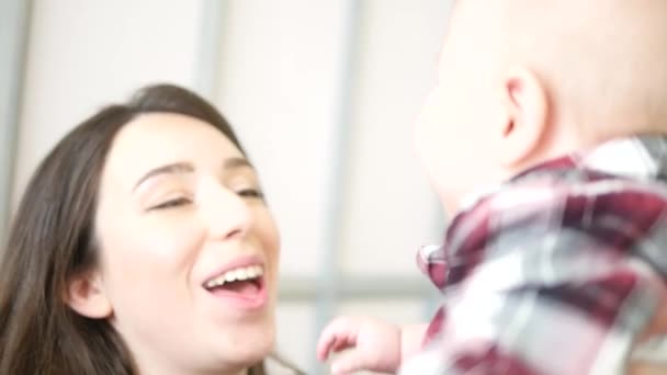 Gelukkige ouders liggen met hun schattige baby zoon op bedat thuis in slaapkamer — Stockvideo