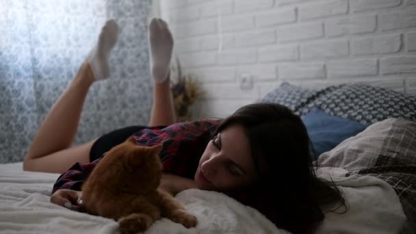 Une fille couche avec un chat sur le lit. 4K — Video