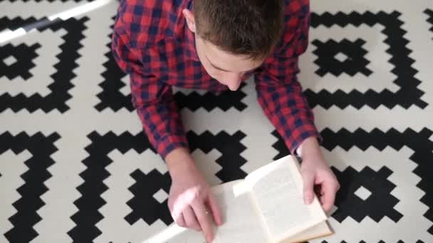 Мужчина читает книгу на диване — стоковое видео