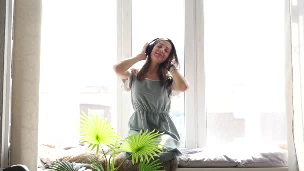 Όμορφη γυναίκα με ακουστικά Ακούστε τη μουσική σε μπλε φόντο — Αρχείο Βίντεο
