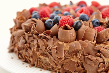 Yabani çilek ve çikolata parçaları ve patates kızartması ile çikolatalı kek görünümünü kapat