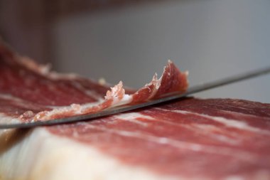 Geleneksel İspanyol yemek jamonu Serrano, özel uzun bir bıçakla kesiyor.