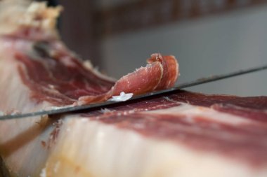 Geleneksel İspanyol yemek jamonu Serrano, özel uzun bir bıçakla kesiyor.