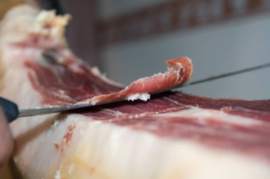 Geleneksel İspanyol yemek jamonu Serrano, özel uzun bir bıçakla kesiyor.