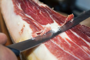 Geleneksel İspanyol yemek jamonu Serrano, özel uzun bir bıçakla kesiyor.