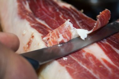 Geleneksel İspanyol yemek jamonu Serrano, özel uzun bir bıçakla kesiyor.