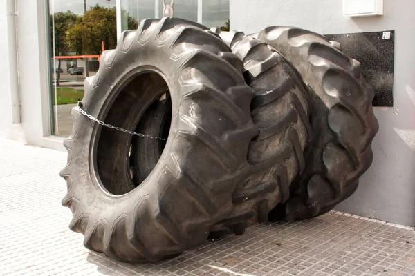 Huge tires from a trailer tied with a chain put up for sale.