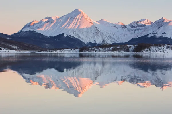 Reflejos de las montañas nevadas al atardecer en el lago Campotosto —  Fotos de Stock