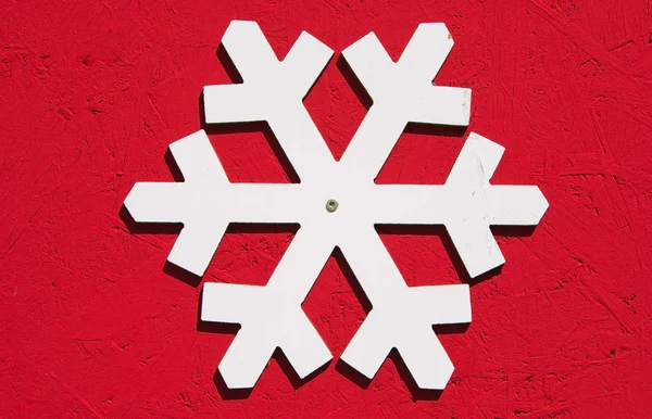 Witte sneeuwvlok geïsoleerd op rode achtergrond — Stockfoto