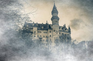 Bavyera Alpleri 'ndeki Neuschwanstein şatosunun harika bir manzarası var. Sisin içinde bulutlarla birlikte kayboldu.