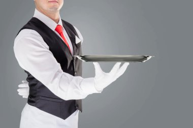 Eldiven ve kırmızı kravat boş tepsi tutarak yakışıklı genç garson