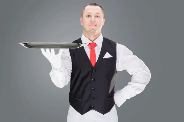 Knappe jonge ober in handschoenen en rode cravat bedrijf leeg lade — Stockfoto