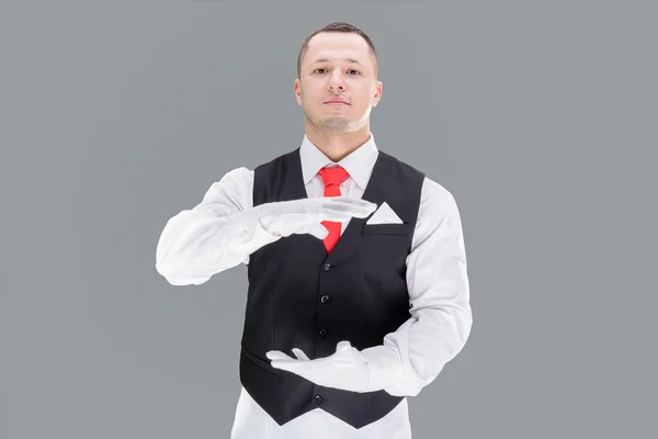 Pohledný mladý číšník v rukavicích a červený nákrčník — Stock fotografie
