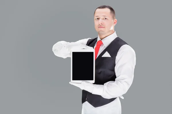 Guapo camarero joven en guantes y cravat rojo sosteniendo la tableta —  Fotos de Stock