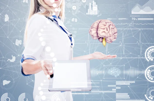 Exposição dupla, médico segurando órgãos humanos (cérebro) e tablet, fundo cinza . — Fotografia de Stock