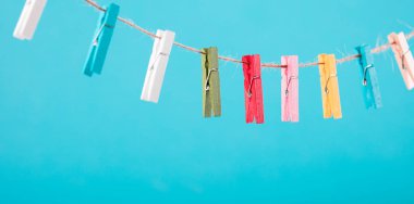 Çiçekler clothesline üzerinde sabitlenmiş. Minimalizm arka plan. Mavi, turuncu, gri arka plan. Yüksek çözünürlüklü fotoğraf.