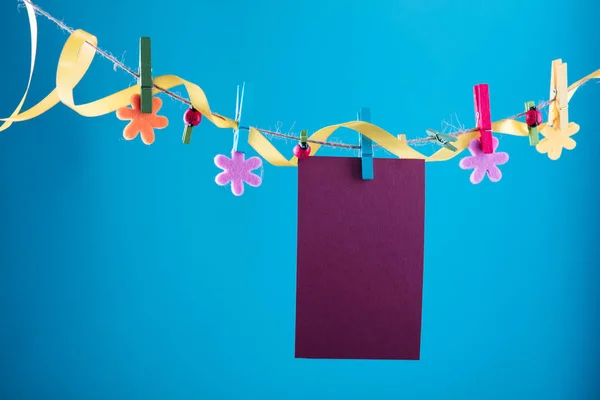 Tomma kort fäst på klädstreck. Kopiera utrymme för formuleringar. Fäst med blomma stift. Blå, orange bakgrund. Högupplöst foto. — Stockfoto