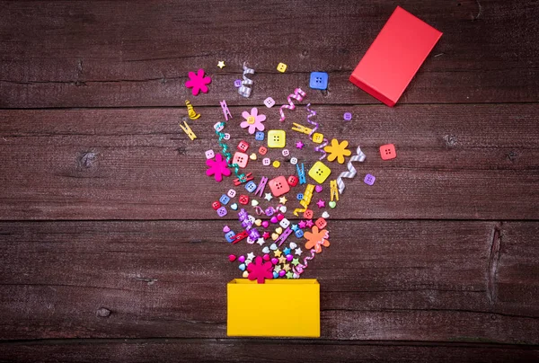 Exploderande firande gul presentbox på en trä bakgrund. Semester-konceptet. — Stockfoto