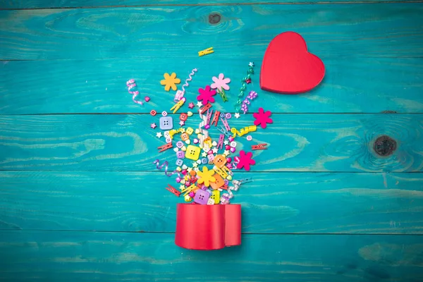 Exploderende viering rode doos van de gift in de vorm van hart op een houten achtergrond. Vakantie concept. — Stockfoto