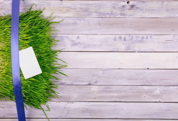 Línea de decoración azul sobre una hierba sobre un panel de madera blanca cepillada. Regalos o cocept celebración. Piso Lay . —  Fotos de Stock