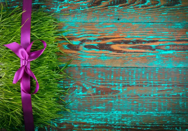 Línea de decoración púrpura en una hierba en un panel de madera azul cepillado. Regalos o cocept celebración. Piso Lay . —  Fotos de Stock