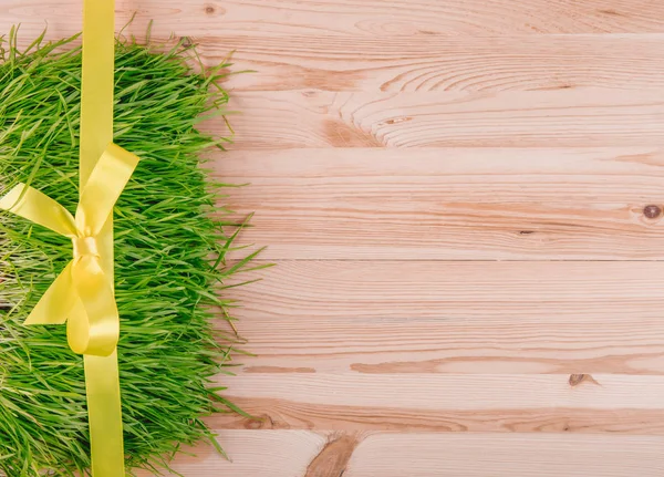 Violette Dekorationslinie auf einem Gras auf einer Holzplatte. Geschenke oder Feierkokett. flache Lage. — Stockfoto