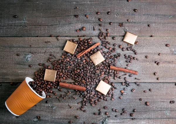 Svart rostade kaffebönor och slipa med kryddorna kanel, anis, kardemumma, kryddnejlika och farinsocker. Svart vintage kaffekvarn, skopor och cup över trä med bränt bakgrund. — Stockfoto