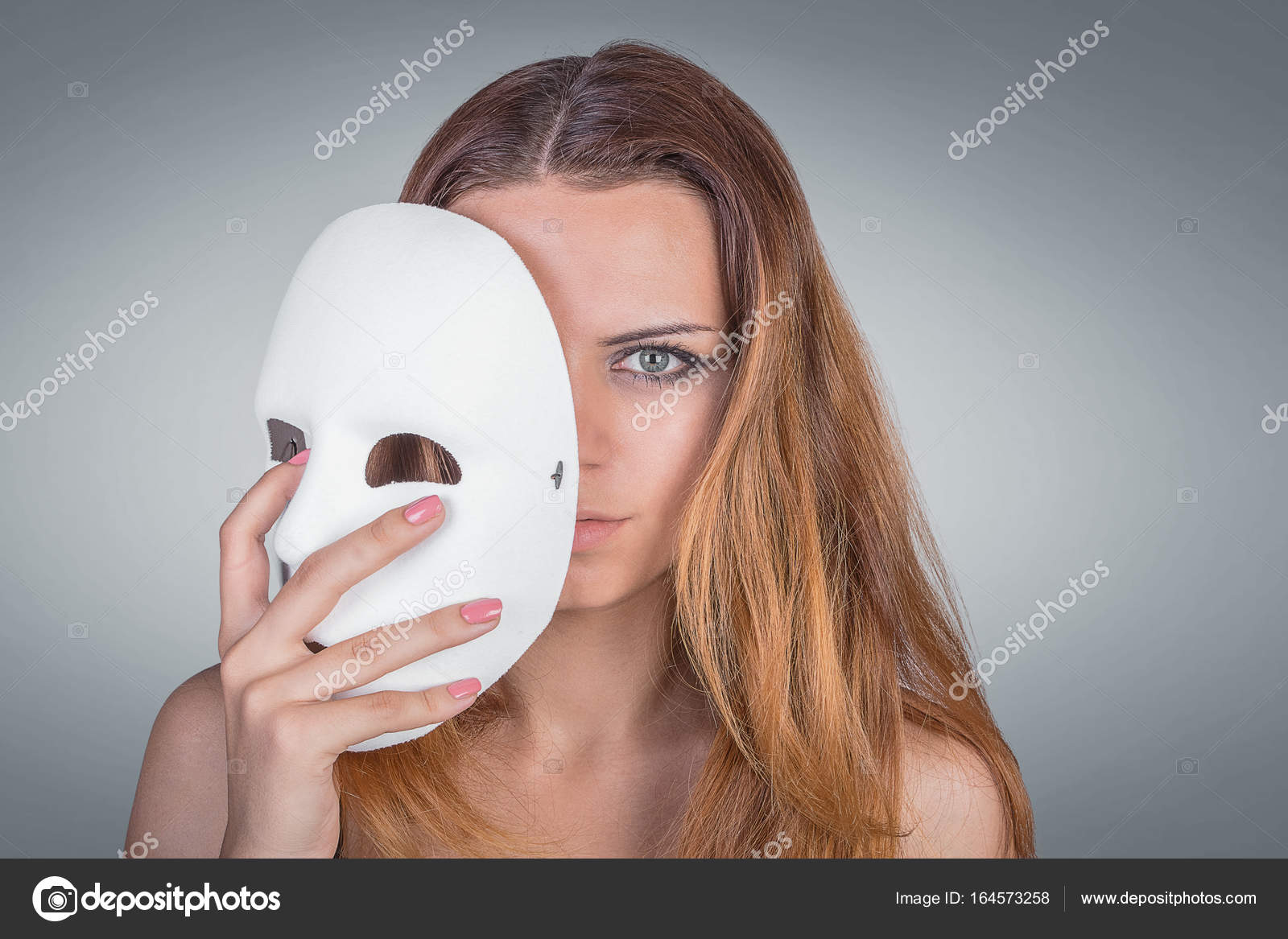 Young emotional woman holding mask in pose in studio on Stock Photo by 164573258