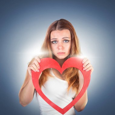 Bir oyuncak kırmızı kalp holding, poz güzel duygusal genç kadın 