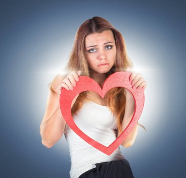 Bir oyuncak kırmızı kalp holding, poz güzel duygusal genç kadın 