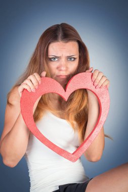 Bir oyuncak kırmızı kalp holding, poz güzel duygusal genç kadın 