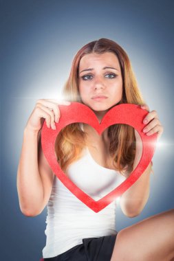 Bir oyuncak kırmızı kalp holding, poz güzel duygusal genç kadın 