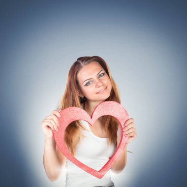 Bir oyuncak kırmızı kalp holding, poz güzel duygusal genç kadın 