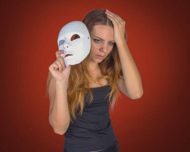 Maske bir el poz Studio tutan genç duygusal kadın 