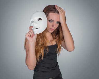 Maske bir el poz Studio tutan genç duygusal kadın 