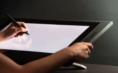 Kadın el profesyonel grafik tablet üzerinde çizim. Siyah backgro