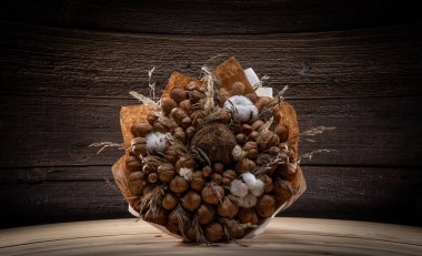 Ahşap arka planda bir kağıt ambalajı üzerinde kahverengi fındık buket