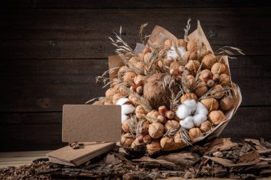 Ahşap arka planda bir kağıt ambalajı üzerinde kahverengi fındık buket