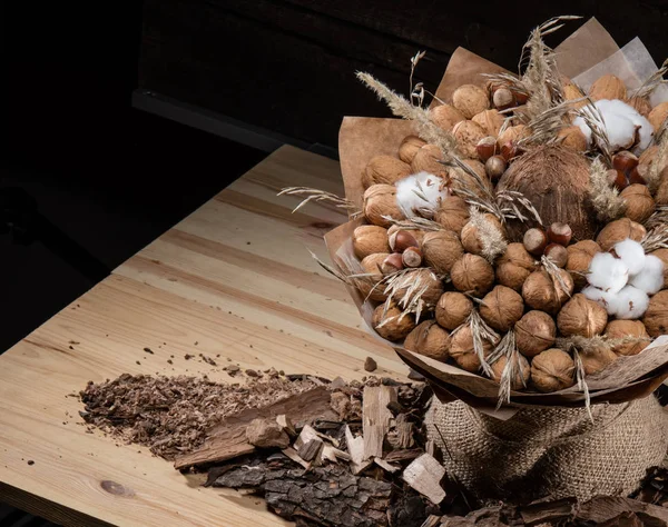 Букет коричневых орехов на деревянном фоне в бумажной обертке — стоковое фото