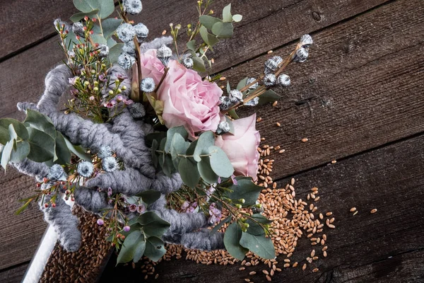 Original and unusual bouquet in a glass vase on a wooden background — Stock Photo, Image